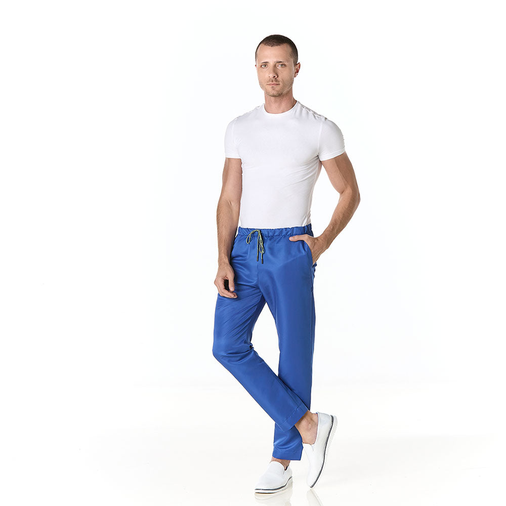 Hombre vistiendo pantalon sanitario tipo jogger azul rey slim fit con elastico en cintura y bolsillos en cadera
