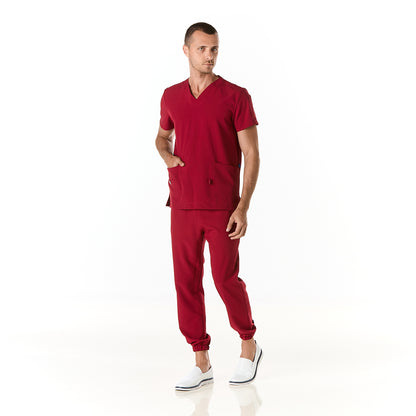 Hombre vistiendo pijama sanitario color vino con cuello en v y pantalon tipo jogger