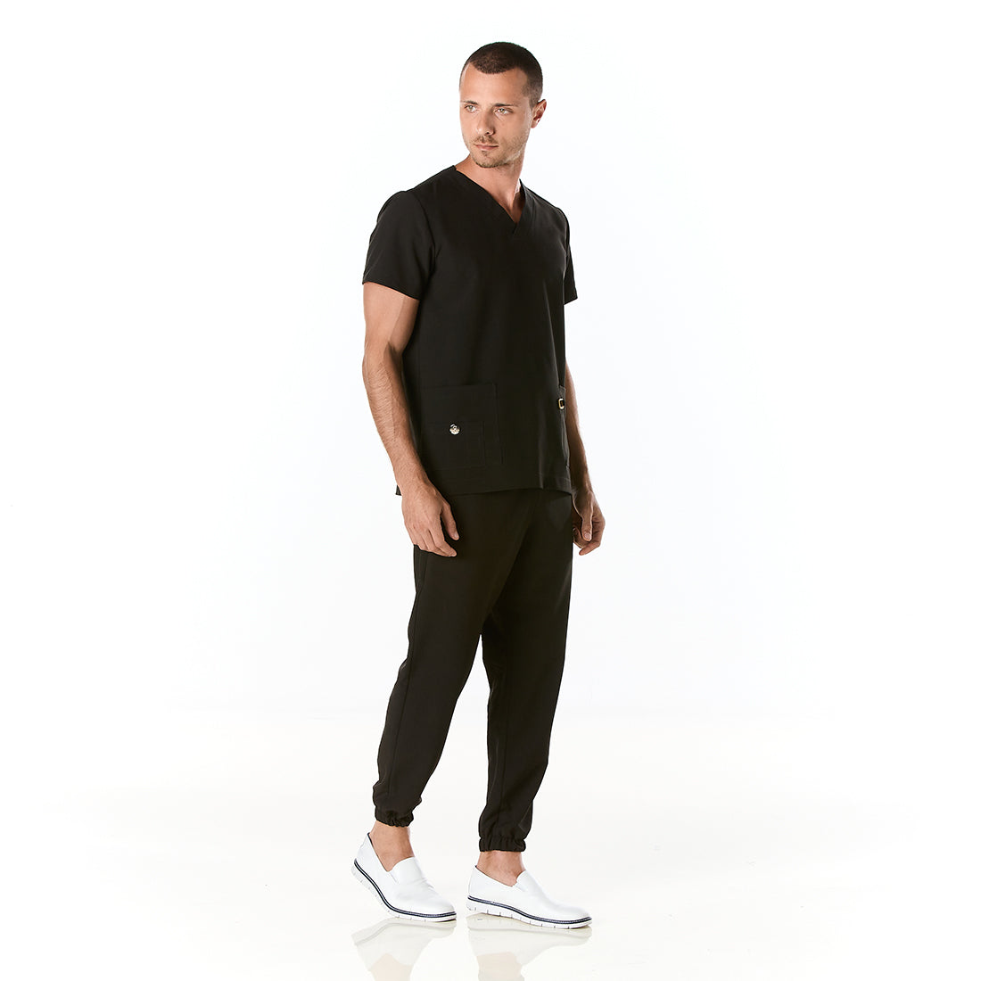 Hombre vistiendo pijama sanitario color negro con cuello en v y pantalon tipo jogger - perfil
