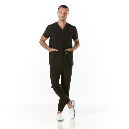 Hombre vistiendo pijama sanitario color negro marino con cuello en v y pantalon tipo jogger