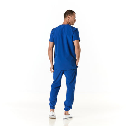 Hombre vistiendo pijama sanitario color azul rey con cuello en v y pantalon tipo jogger - espalda