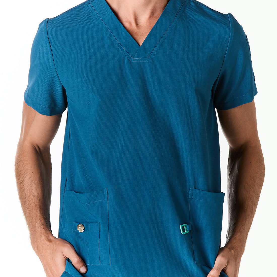 Hombre vistiendo pijama sanitario color azul turquesa con cuello en v y hebilla porta gafete