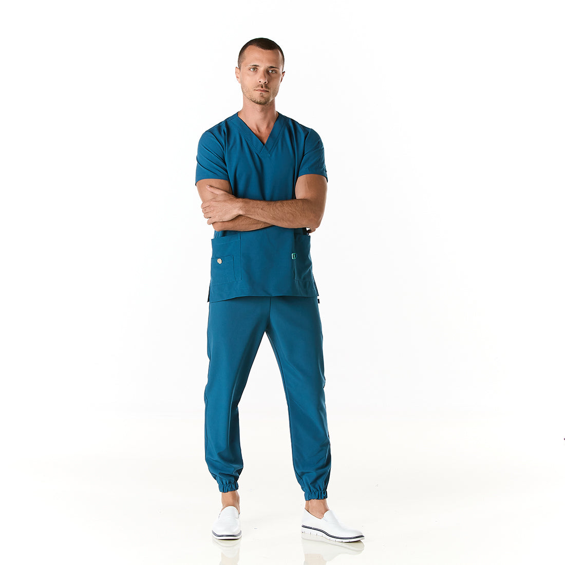 Hombre vistiendo pijama sanitario color azul turquesa con cuello en v y pantalon tipo jogger