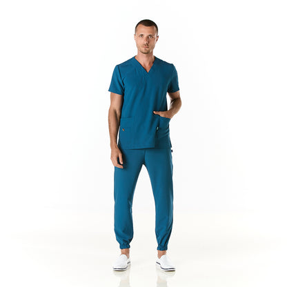 Hombre vistiendo pijama sanitario color azul turquesa con cuello en v y pantalon tipo jogger - frente