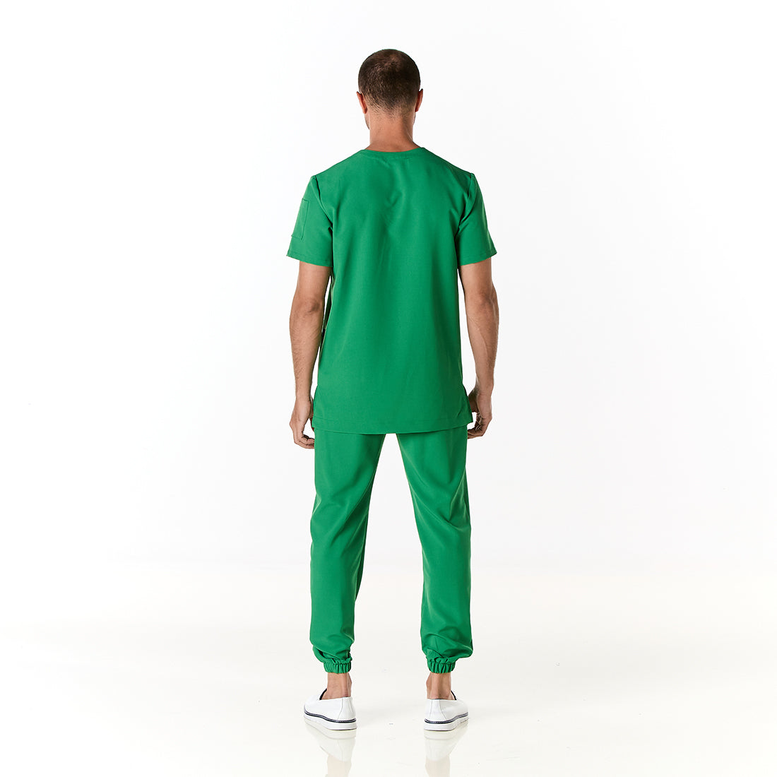 Hombre vistiendo pijama sanitario color verde perico con cuello en v y pantalon tipo jogger - espalda
