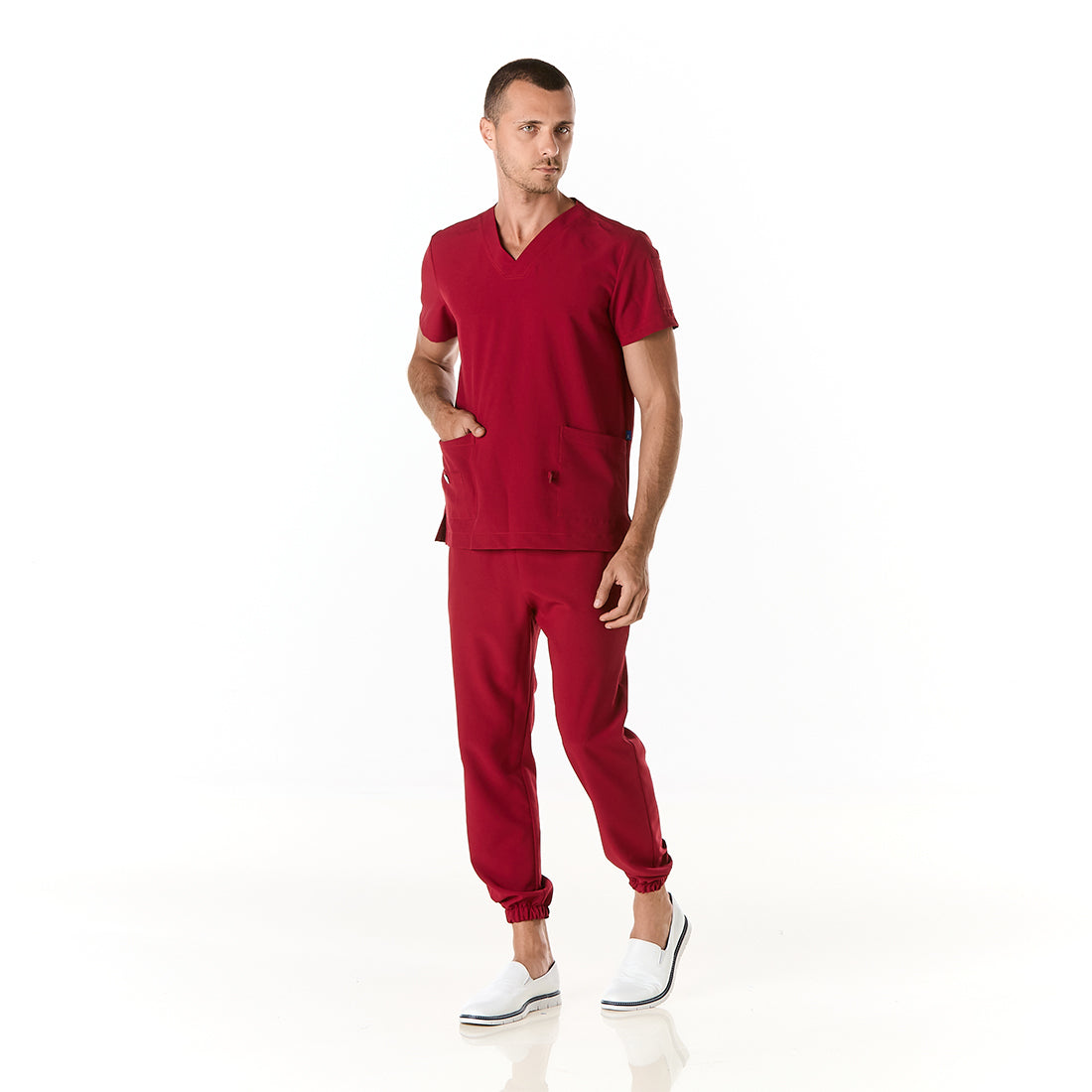 Hombre vistiendo pijama sanitario color vino con cuello en v y pantalon tipo jogger