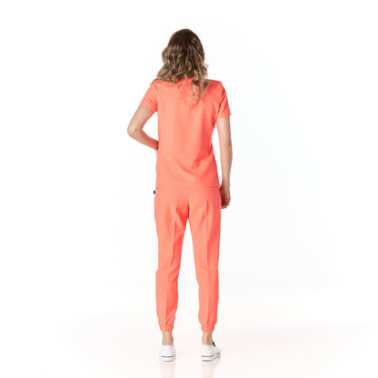 Mujer vistiendo pijama sanitario color fresa con cuello en v y pantalon tipo jogger - espalda