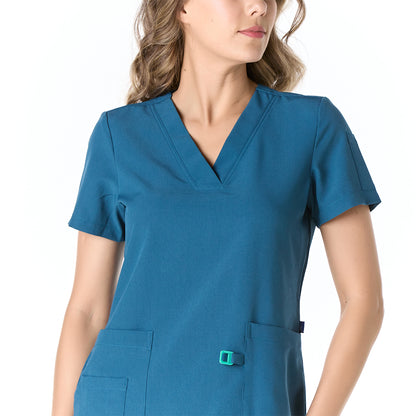 Mujer vistiendo pijama sanitario color azul turquesa con cuello en v y hebilla porta gafete