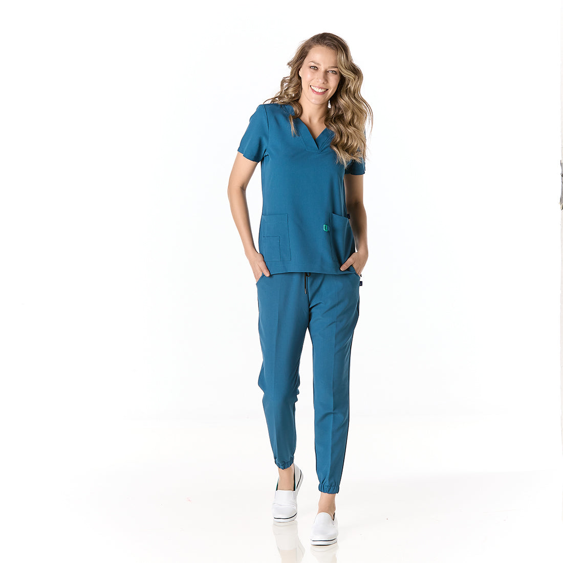 Mujer vistiendo pijama sanitario color azul turquesa con cuello en v y pantalon tipo jogger